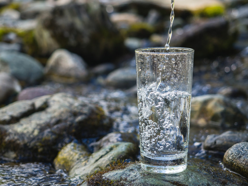 Glass med vann i naturen
